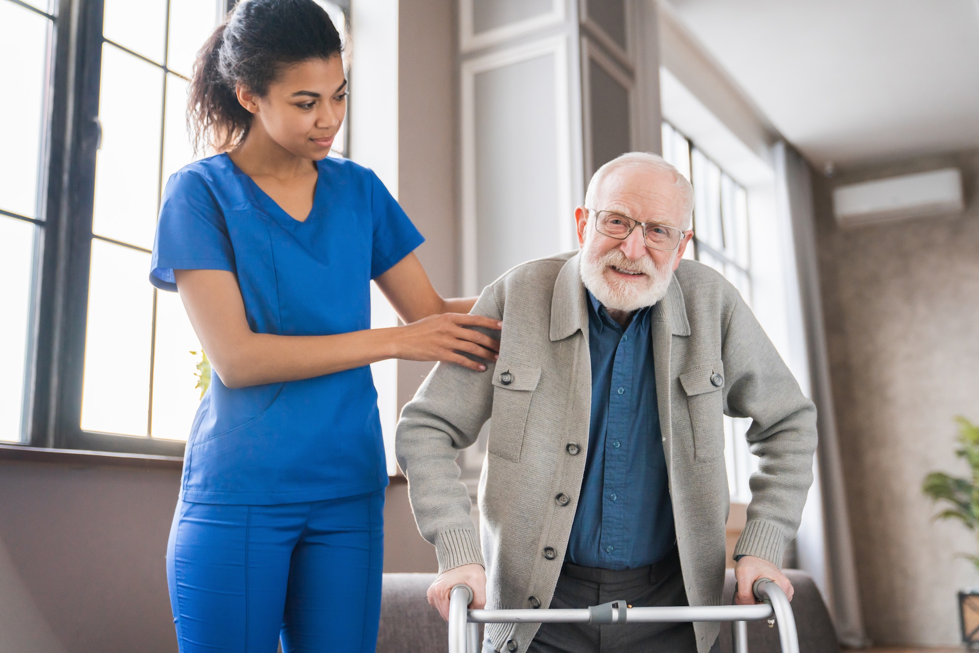 handicapped-man-using-walker-rehabilitation-at-home-nurse-helping-disabled-man-using-walker.jpg